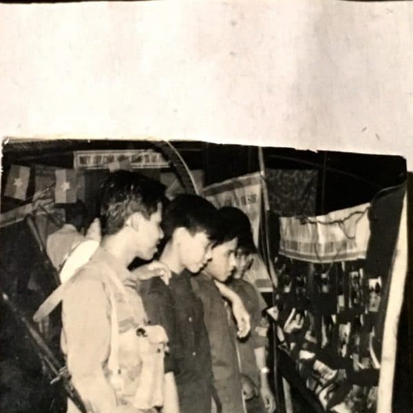 Photograph of Viet Cong Looking at Propaganda Photos